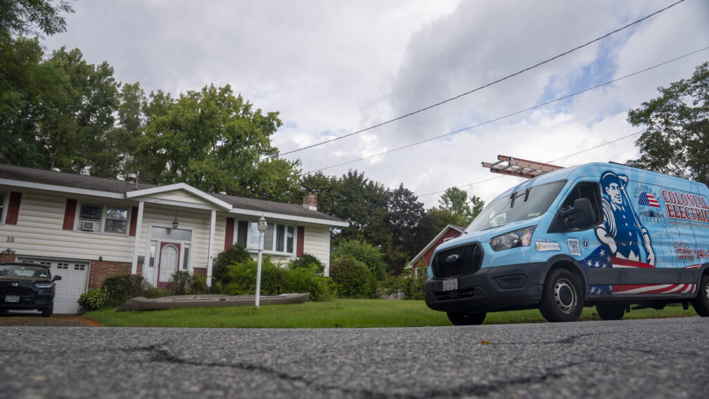 Colonial Electric van with ladder rack parked on a residential street, wide view